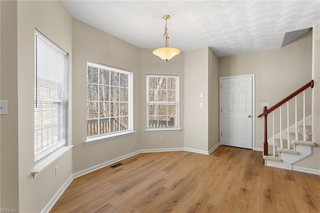 entrance foyer featuring stairway, baseboards, visible vents, and wood finished floors