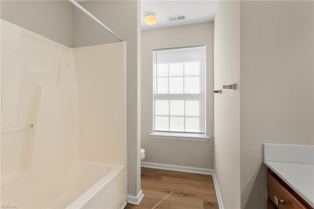 bathroom with visible vents, toilet, wood finished floors, baseboards, and vanity