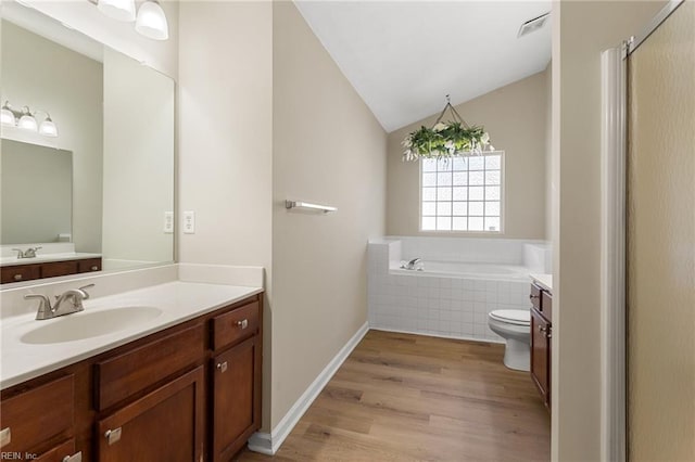 full bathroom featuring visible vents, a garden tub, wood finished floors, vanity, and vaulted ceiling