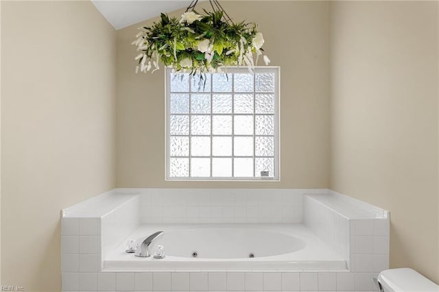 bathroom featuring plenty of natural light, toilet, and a whirlpool tub