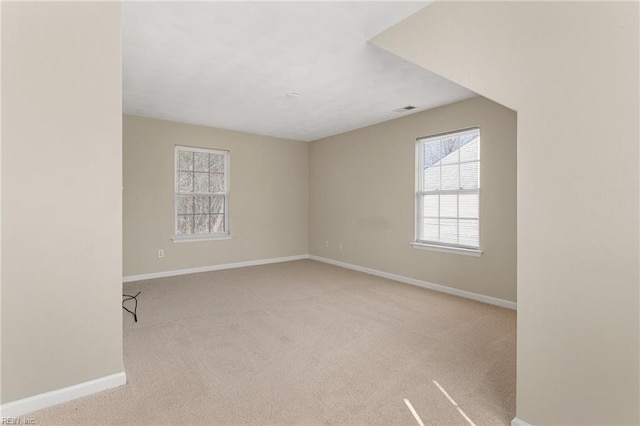 carpeted empty room with visible vents and baseboards