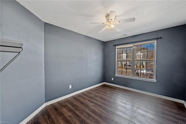 spare room with a ceiling fan, wood finished floors, and baseboards