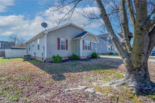 view of side of home featuring crawl space, cooling unit, and fence