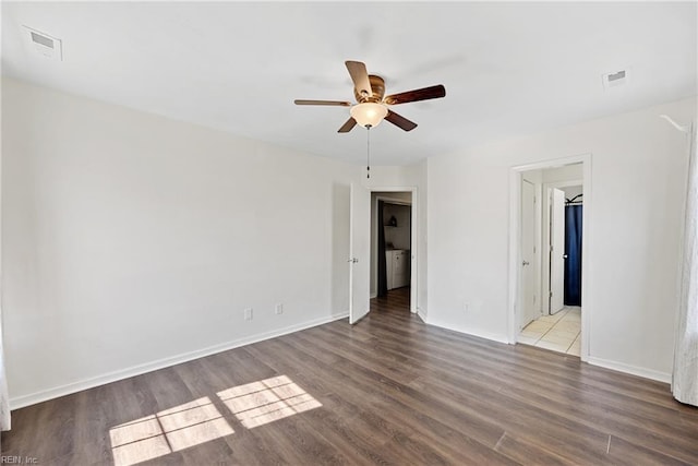 unfurnished room with a ceiling fan, wood finished floors, visible vents, and baseboards