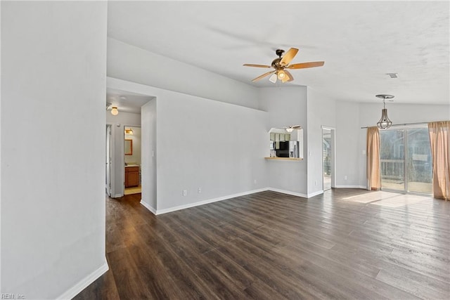 unfurnished living room with baseboards, dark wood-type flooring, a ceiling fan, and vaulted ceiling