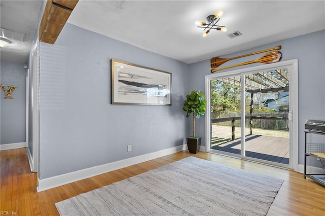 dining area with visible vents, attic access, baseboards, and wood finished floors