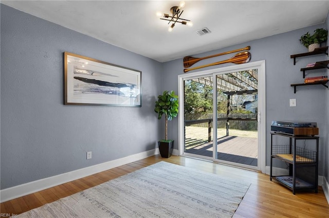 doorway with visible vents, baseboards, and wood finished floors