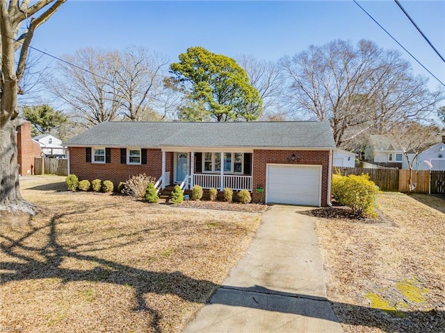 ranch-style home featuring fence, driveway, an attached garage, covered porch, and brick siding