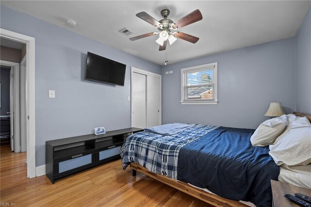 bedroom with baseboards, visible vents, ceiling fan, a closet, and light wood-type flooring