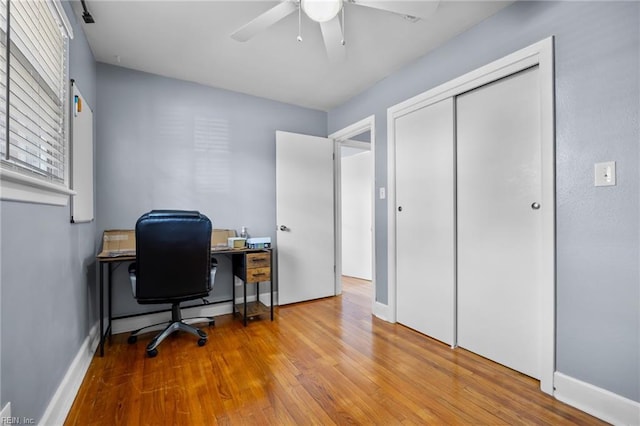 office space featuring ceiling fan, baseboards, and wood finished floors