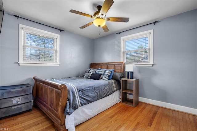 bedroom with ceiling fan, light wood-type flooring, and baseboards