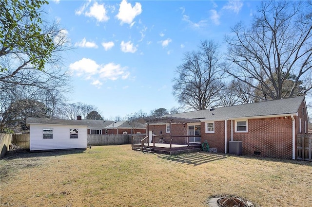 back of house featuring brick siding, a lawn, a pergola, and a fenced backyard