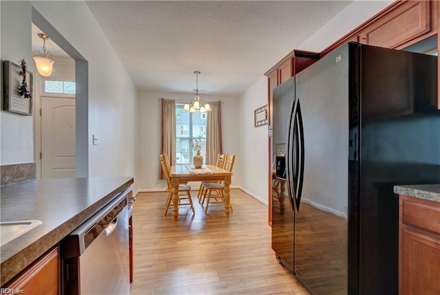 interior space with baseboards, a textured ceiling, an inviting chandelier, and light wood finished floors