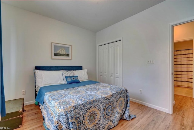 bedroom featuring baseboards, a closet, and light wood finished floors