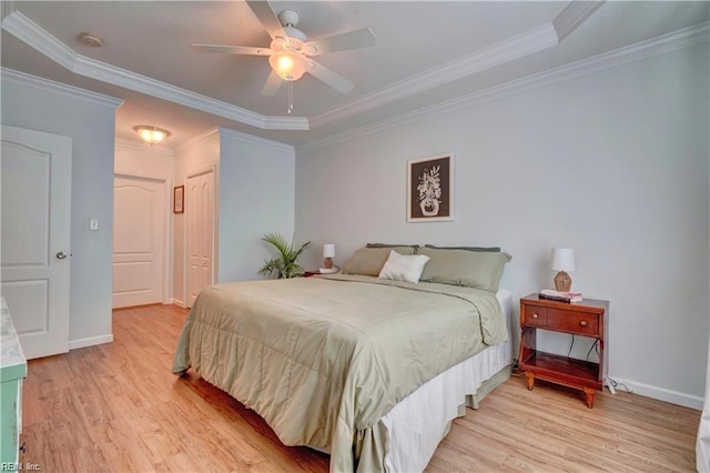 bedroom with ornamental molding, a closet, light wood-style floors, baseboards, and ceiling fan