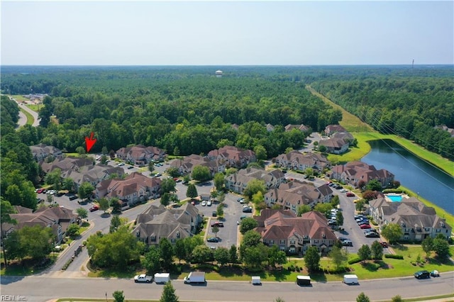 aerial view with a forest view, a residential view, and a water view