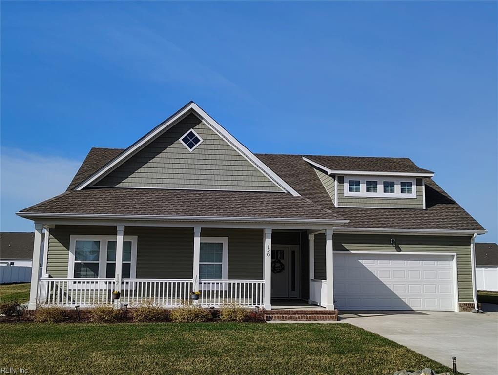 view of front of house with roof with shingles, a porch, an attached garage, concrete driveway, and a front lawn