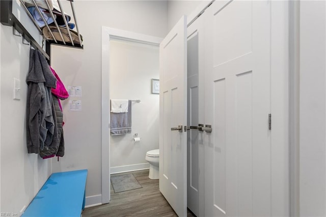 bathroom featuring baseboards, toilet, and wood finished floors