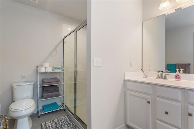 bathroom featuring toilet, a stall shower, vanity, and tile patterned flooring