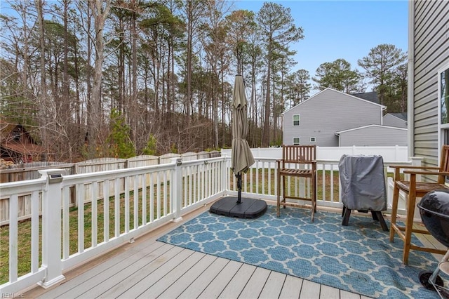 wooden terrace with a fenced backyard