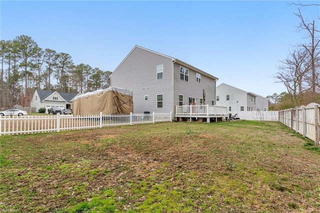 rear view of house featuring a yard, a deck, and a fenced backyard