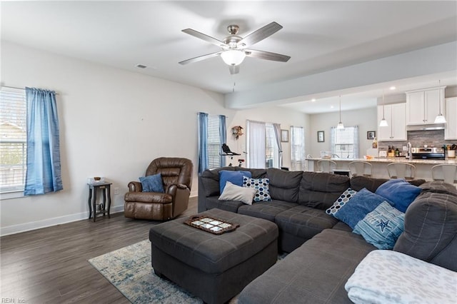 living area featuring visible vents, baseboards, recessed lighting, ceiling fan, and dark wood-type flooring