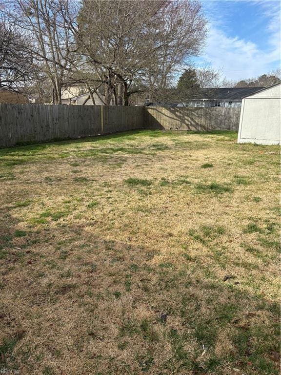 view of yard with a shed, an outdoor structure, and a fenced backyard