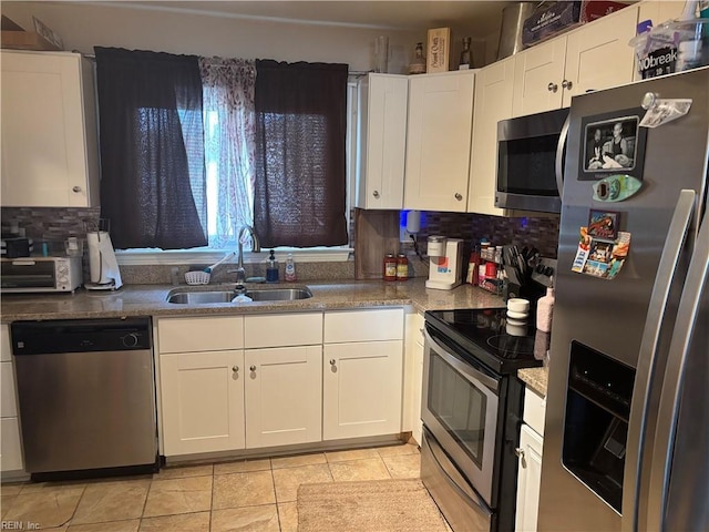 kitchen with a sink, white cabinets, and stainless steel appliances