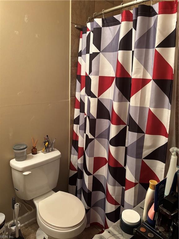 full bathroom with a shower with curtain and toilet