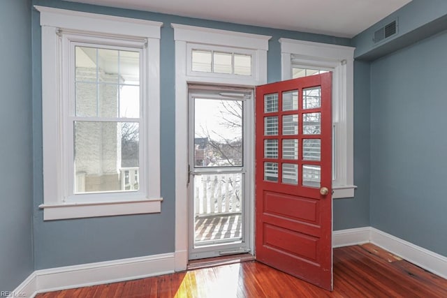 doorway to outside with visible vents, baseboards, and wood finished floors