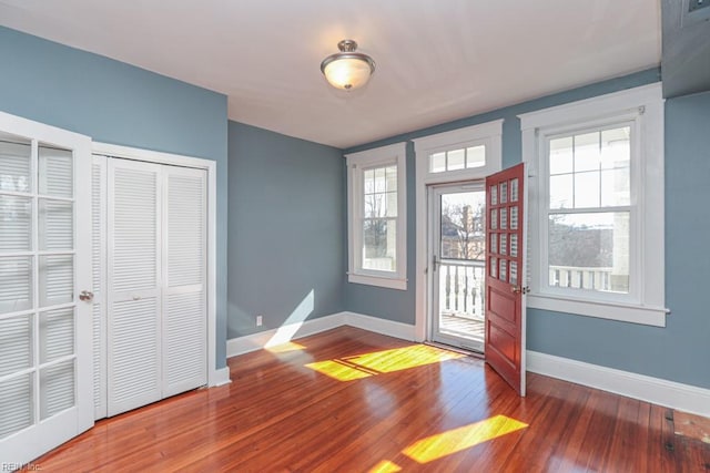 entryway with baseboards and wood-type flooring