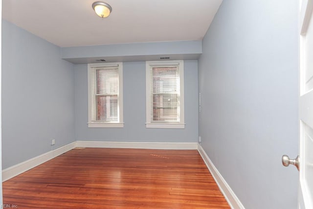 unfurnished room with wood finished floors and baseboards