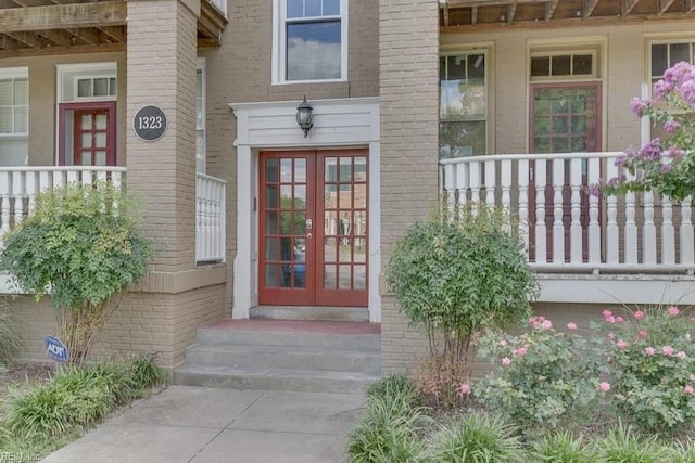 doorway to property featuring french doors and brick siding