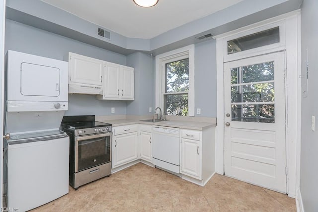 kitchen featuring a sink, under cabinet range hood, stainless steel electric range, white dishwasher, and stacked washer / drying machine