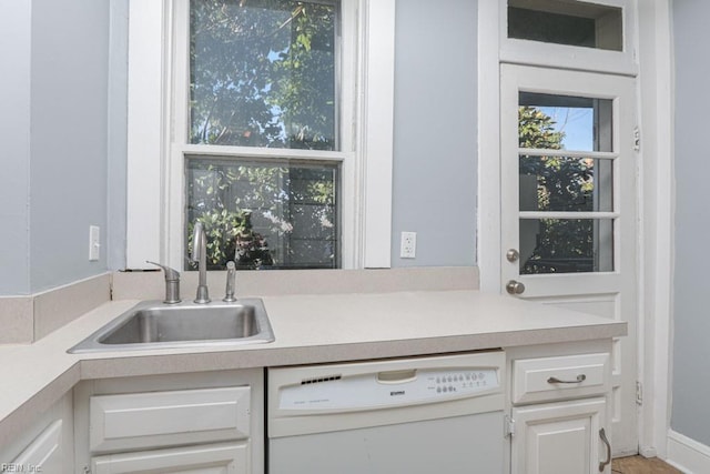 kitchen with dishwasher, light countertops, and a sink