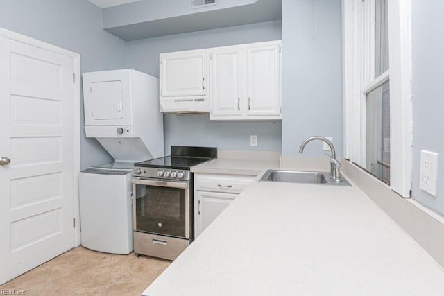 kitchen featuring under cabinet range hood, stacked washer and dryer, stainless steel electric range, white cabinetry, and a sink