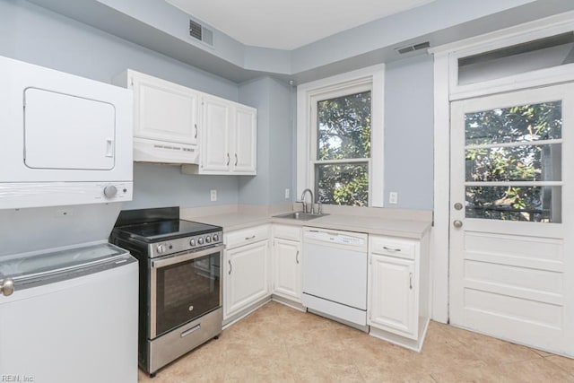 kitchen with visible vents, dishwasher, stainless steel electric range oven, stacked washer / drying machine, and a sink