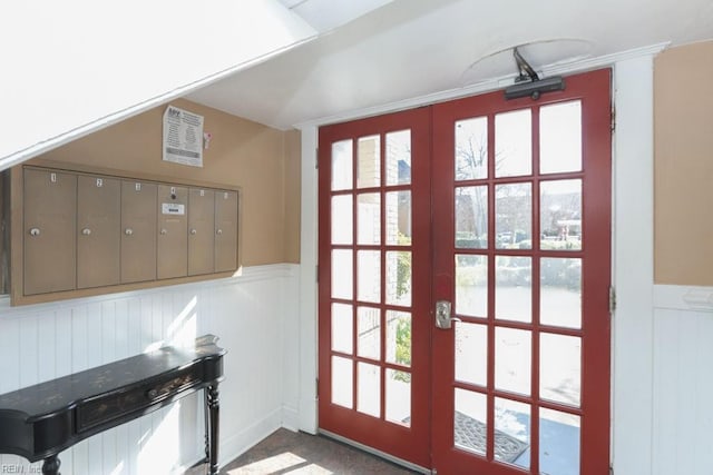 doorway with mail area, french doors, and wainscoting