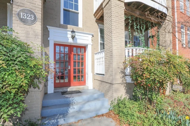 property entrance featuring french doors and brick siding