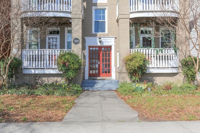 doorway to property with brick siding and a balcony