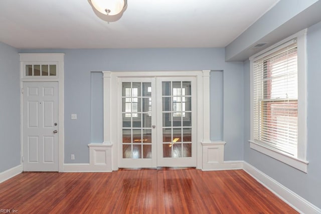 doorway to outside with french doors, decorative columns, baseboards, and wood finished floors