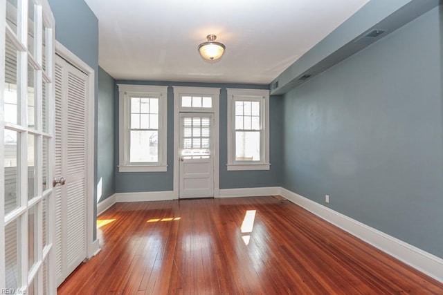 foyer featuring visible vents, baseboards, and hardwood / wood-style floors