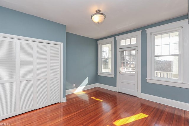 interior space featuring a closet, baseboards, and wood finished floors