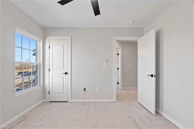 unfurnished bedroom featuring a ceiling fan and baseboards