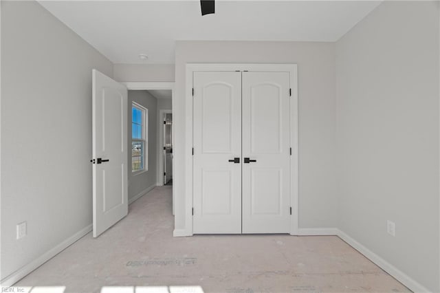 unfurnished bedroom with baseboards, a closet, and ceiling fan