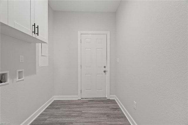 laundry room featuring washer hookup, cabinet space, dark wood-style flooring, and baseboards