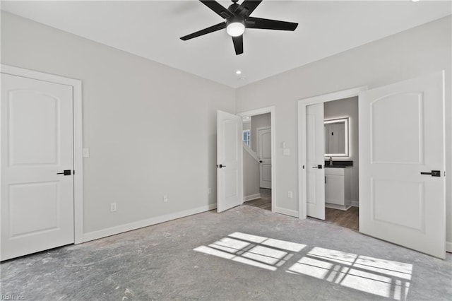 unfurnished bedroom with connected bathroom, a ceiling fan, and baseboards