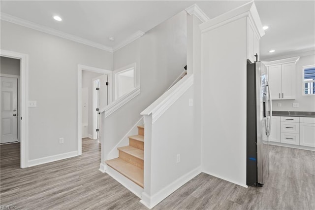 stairway featuring crown molding, recessed lighting, and wood finished floors