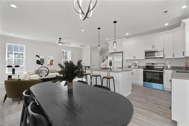 dining area with crown molding, light wood-style flooring, recessed lighting, and visible vents