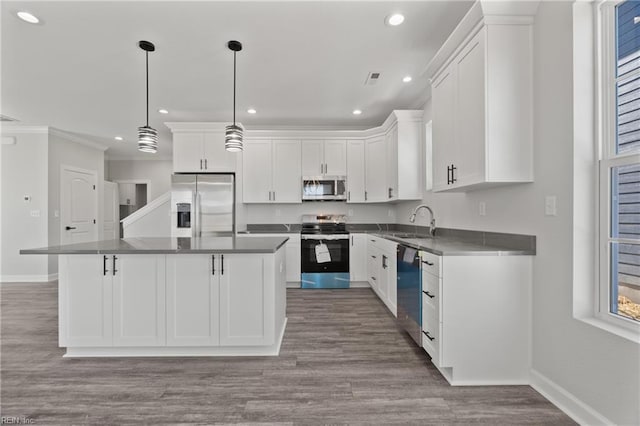 kitchen featuring dark countertops, white cabinets, appliances with stainless steel finishes, and a sink